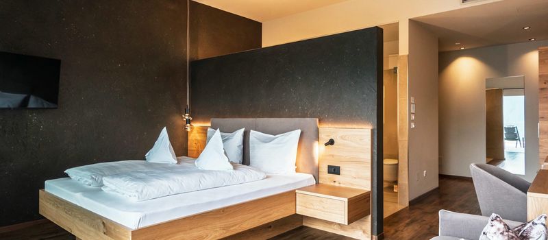 Camera da letto moderna con letto matrimoniale in legno e parete nera